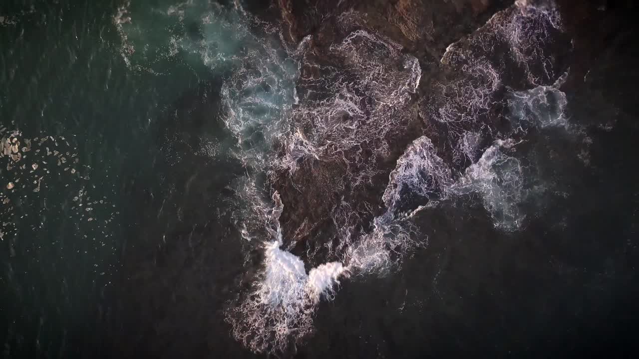 Waves breaking on rocks in California - birds-eye view