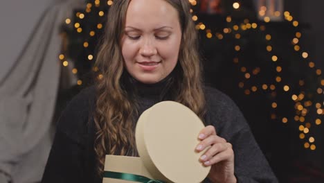 la mujer recibe un regalo redondo de navidad y lo abre con decepción para devolvérselo al donante.