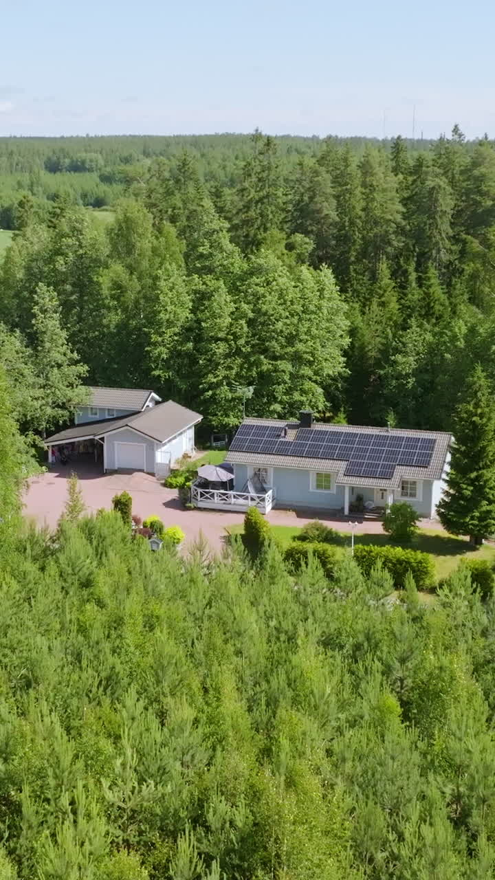 Vertical drone shot revealing a renewable energy powered house, summer day