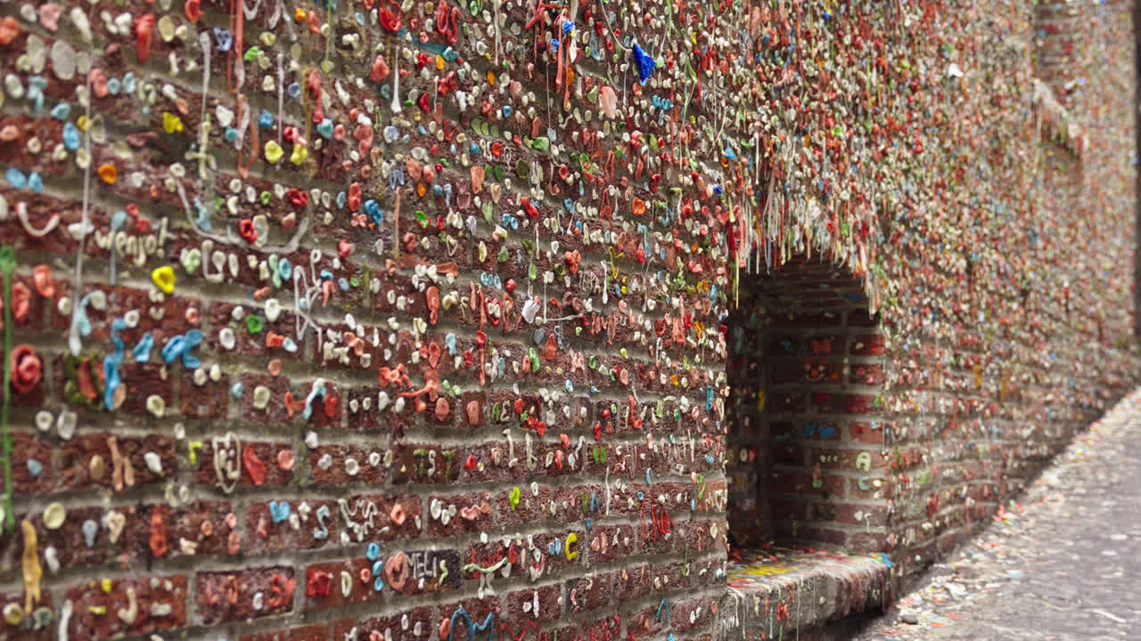 Fixed shot starting out of focus and then shifting to sharp view of gum-covered wall