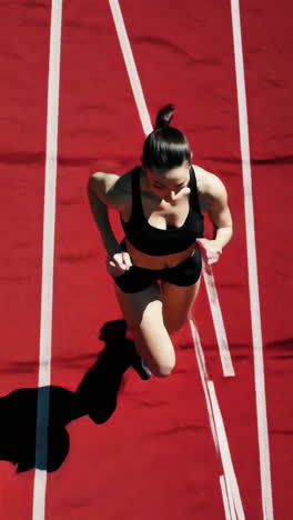 female athlete running on a red track