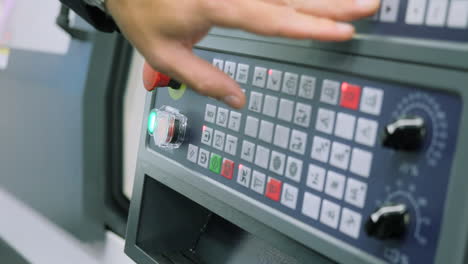 close-up of a cnc machine control panel with hand