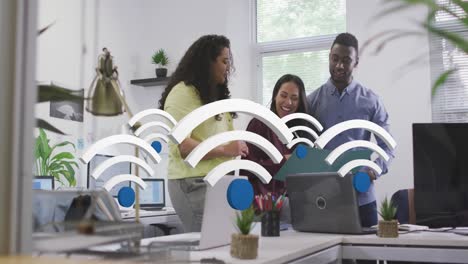 Animation-of-multiple-wi-fi-icons-floating-over-diverse-colleagues-high-fiving-each-other-at-office