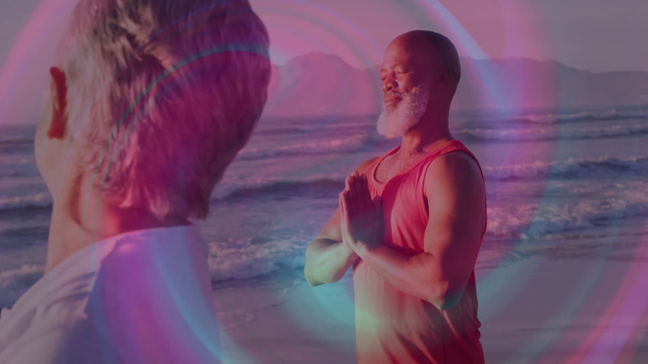 Male and female yoga partners practicing prayer pose on beach, with animated health icons