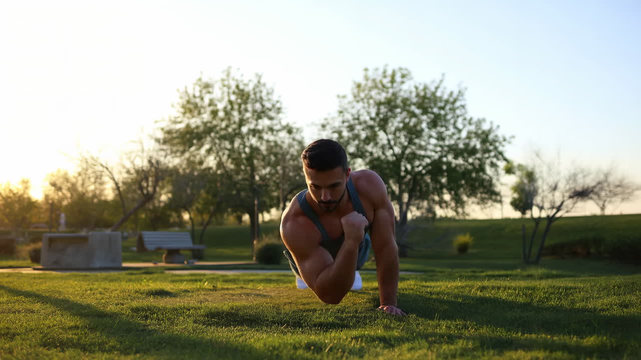 Muscular Man Doing One-Arm Push-Ups in a Sunny Park