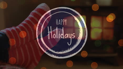 animation of happy holidays text over christmas socks