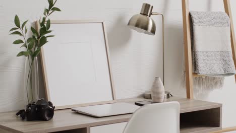 white frame with copy space on white background with plant on desk against white wall