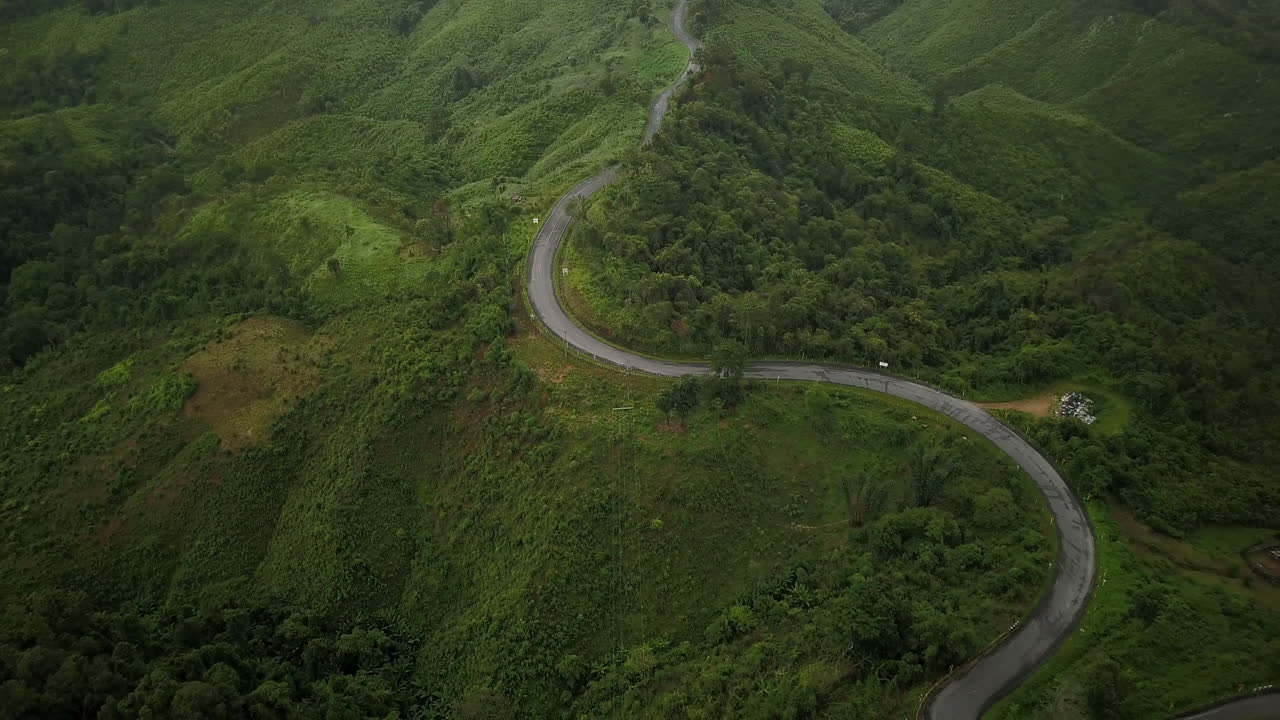 vista aérea volando sobre la exuberante montaña verde de la selva tropical con nubes de lluvia durante la temporada de lluvias en el parque nacional reservado de la montaña doi phuka en el norte de tailandia