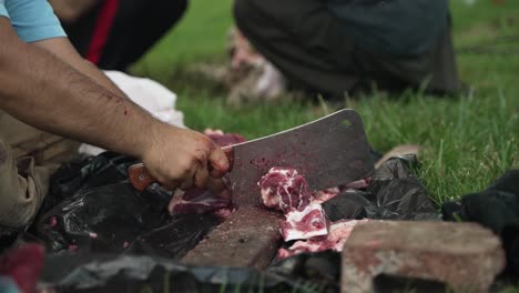 middle eastern man chops and cuts sheep meat to eat in celebration of muslim, religious holiday ramada, eid al-adha or eid al-fitr in cinematic slow motion