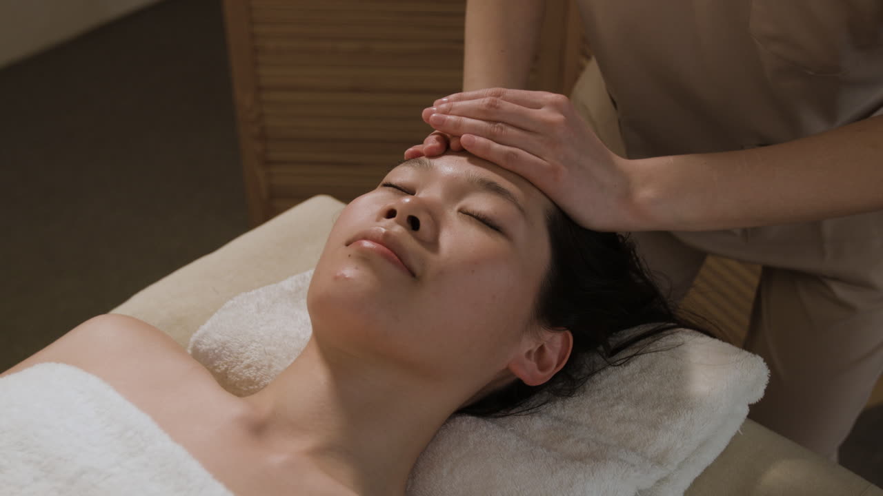 Woman Receiving a Relaxing Head and Face Massage at a Spa