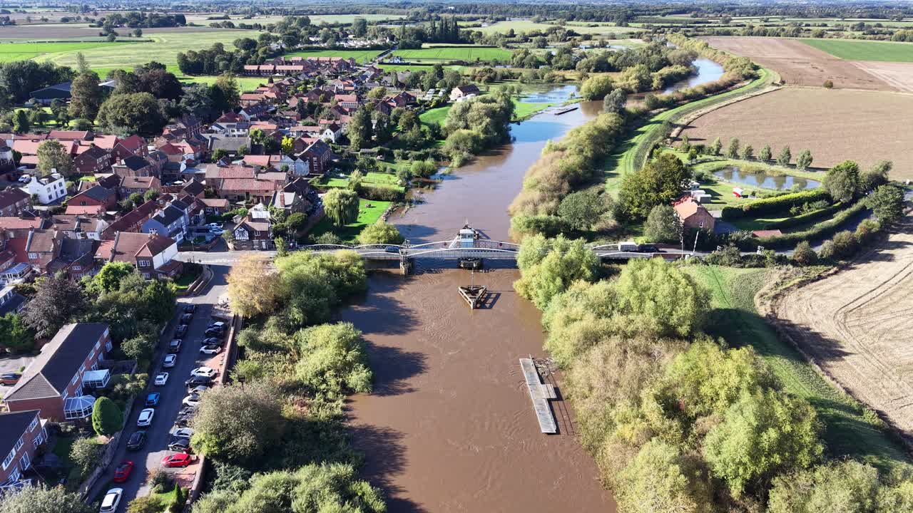 Luftopptak med drone av Myton svingbro over elven Hull i Hull, East Yorkshire, England, som viser omkringliggende landsby, elvebredder, trær og landskap