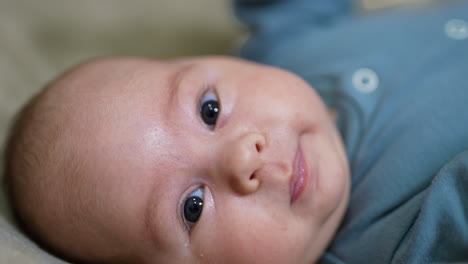 adorable baby face looking in camera. grey-eyed baby lying with his head facing camera. close up.