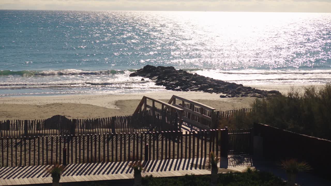 해변과 방파제로 갈 수 있는 나무 다리가 있는 길