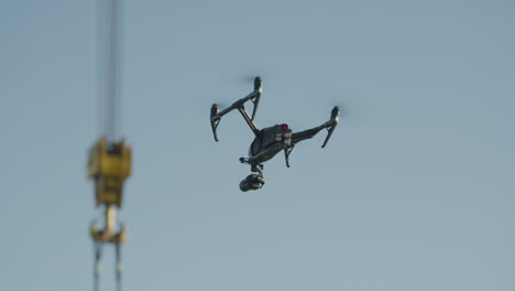 un dron con una cámara vuela cerca de una grúa