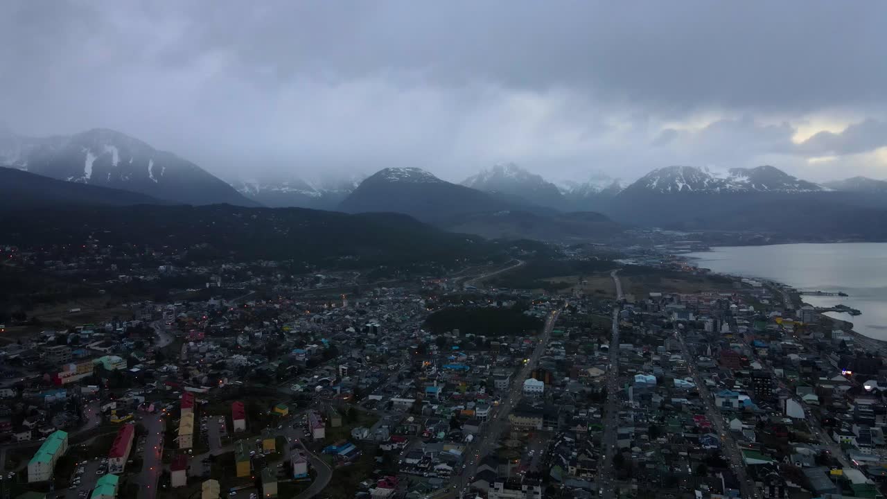 drone disparado volando sobre ushuaia, argentina hacia las montañas de los andes al anochecer