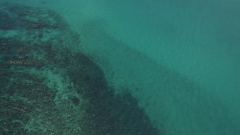 reef rocks submerged under turquoise blue sea