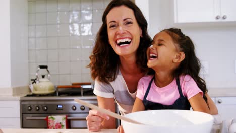 Daughter-and-mother-having-fun-while-preparing-cookies