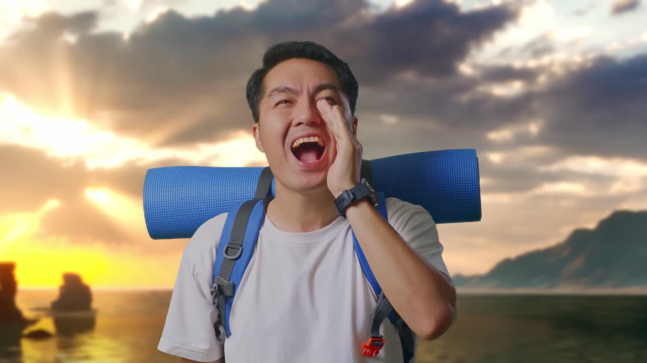Close Up Pendaki Pria Asia Dengan Ransel Gunung Berteriak Sambil Memegang Tangan Di Dekat Mulutnya di Pantai