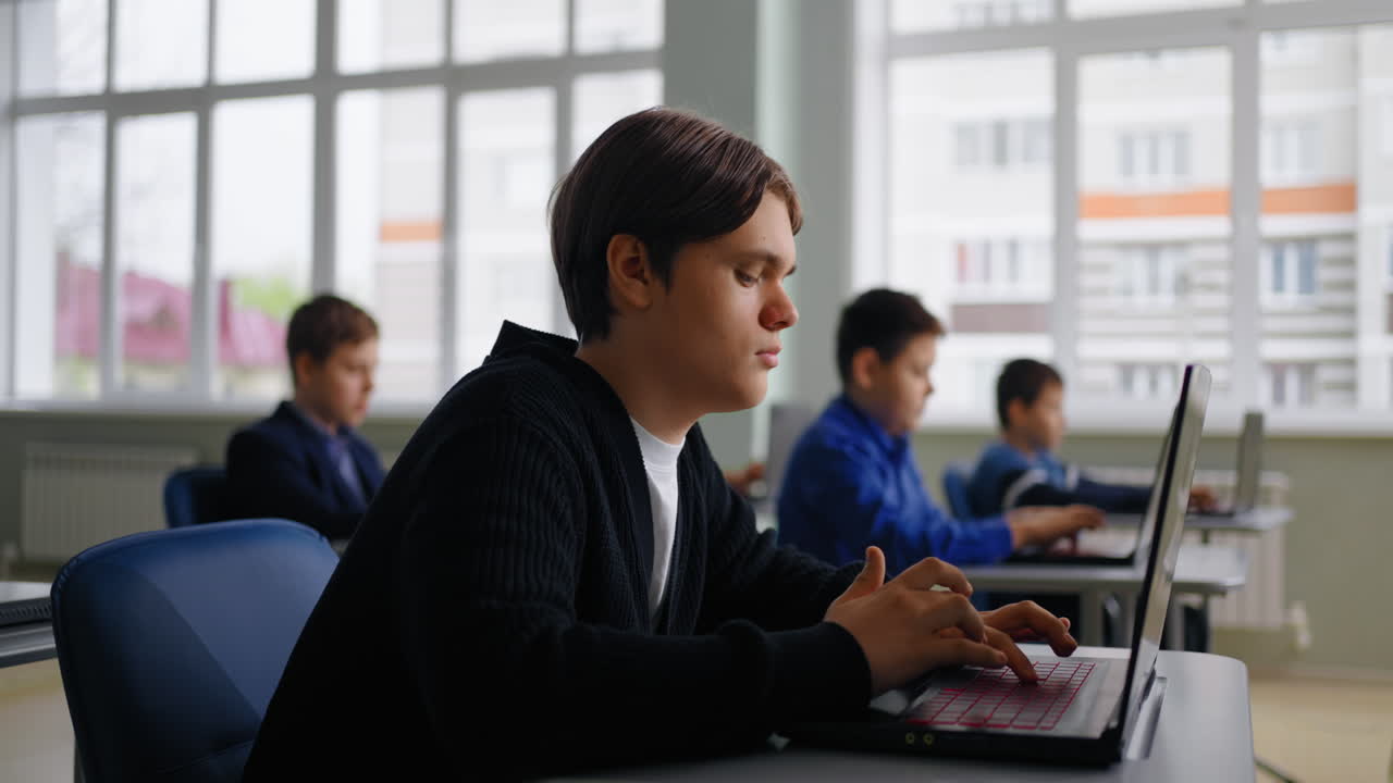 Students working on laptops in a classroom