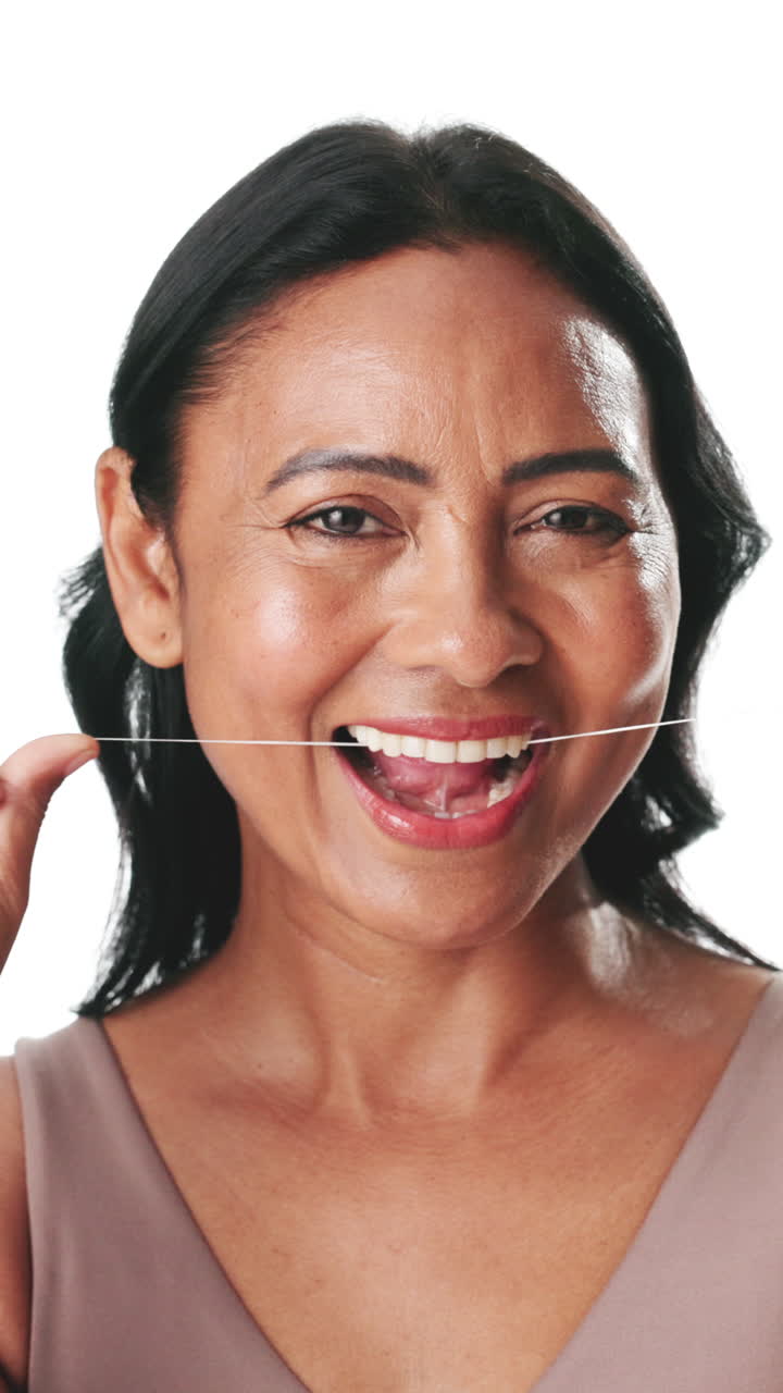Mature Woman Flossing Teeth and Showing Disgusted then Happy Expression