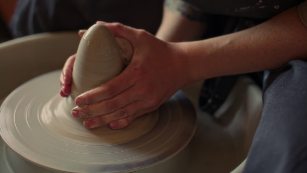 Hands of Artisan Sculpting Clay on Fast-Spinning Pottery Wheel