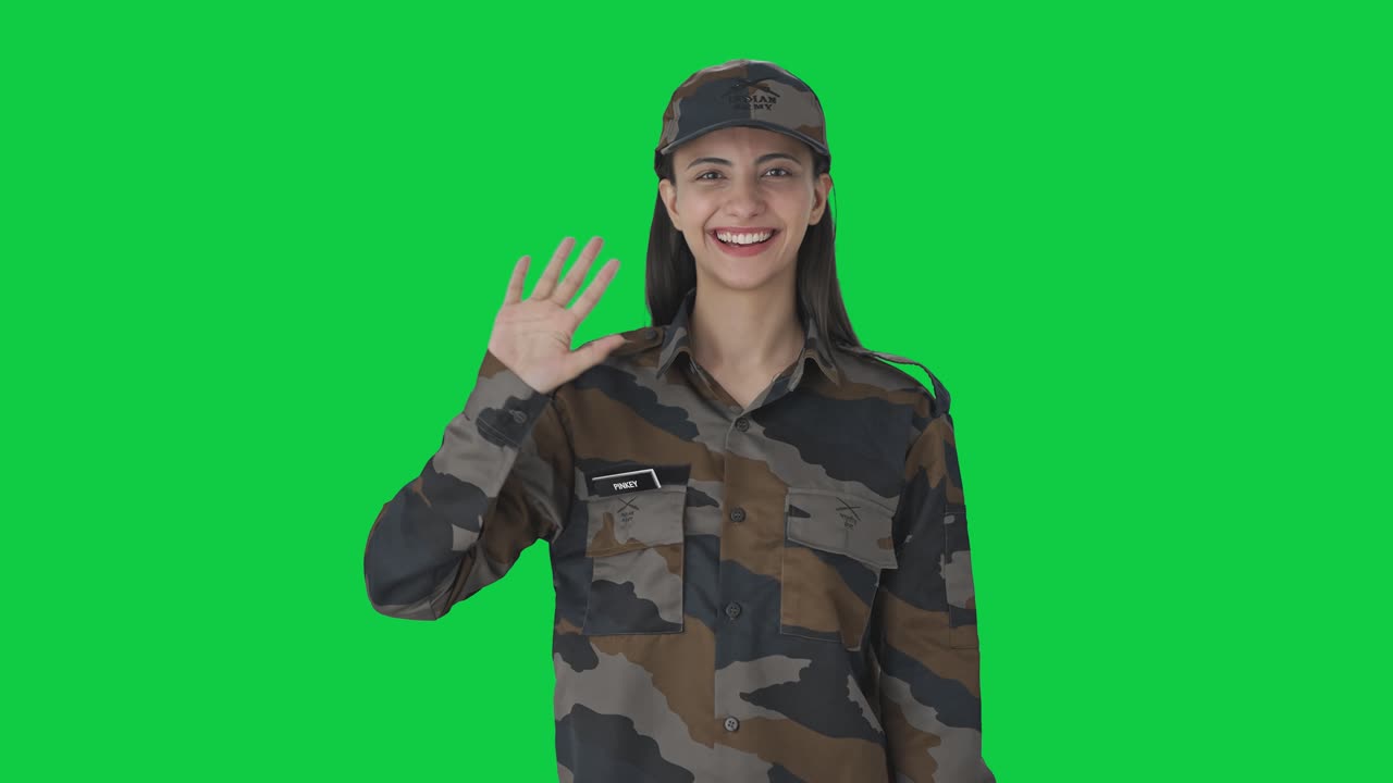 Happy Indian woman army officer waving Hi Green screen