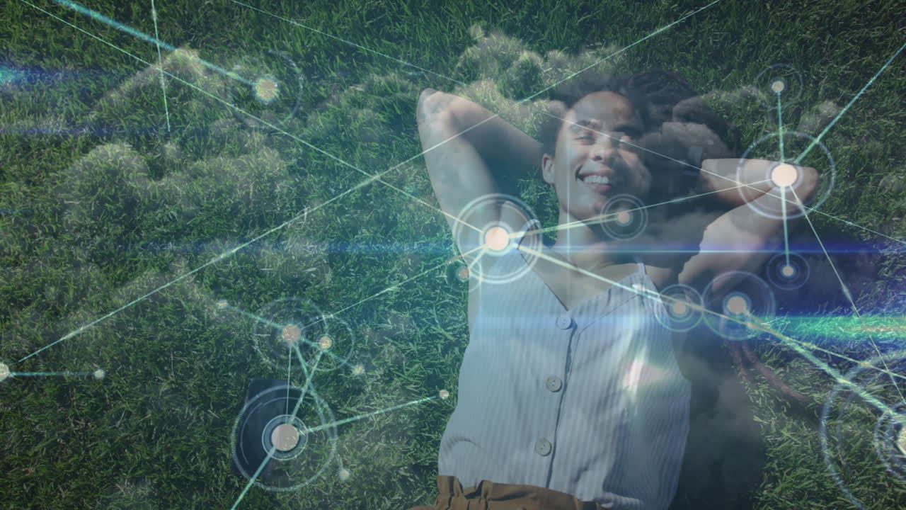 red de conexiones contra la mujer afroamericana sonriendo mientras yacía en la hierba