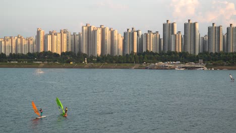 windsurf urbano en el río han en el distrito jamsil de seúl al atardecer, club de surf ttuseom park, apartamentos en el fondo
