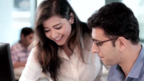 a focused, smiling and attractive male and female associates working on an important business project before the deadline.