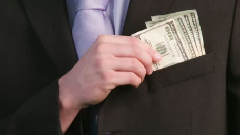 businessman putting money in pocket