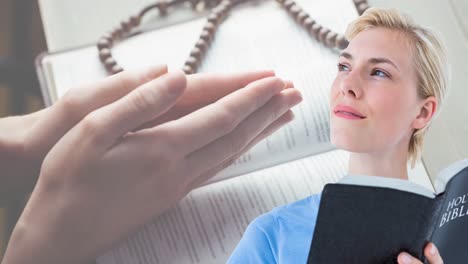 animation of caucasian woman praying and holding holy bible with rosary in background