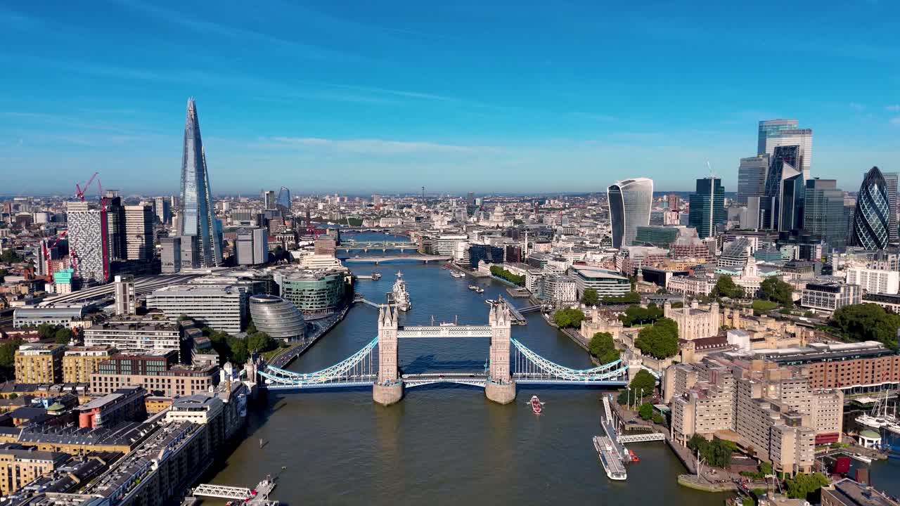Drone footage captures the stunning London skyline along the River Thames, showcasing iconic landmarks like Tower Bridge, City Hall, The Shard, and the historic Tower of London.