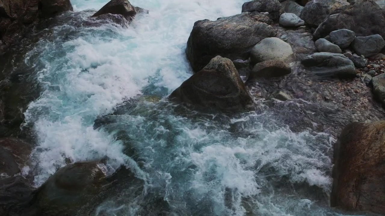 Fiume di montagna limpido che scorre sulle rocce con acqua in rapido movimento. Scena naturale all'aperto con movimento dinamico e atmosfera fresca e pulita.