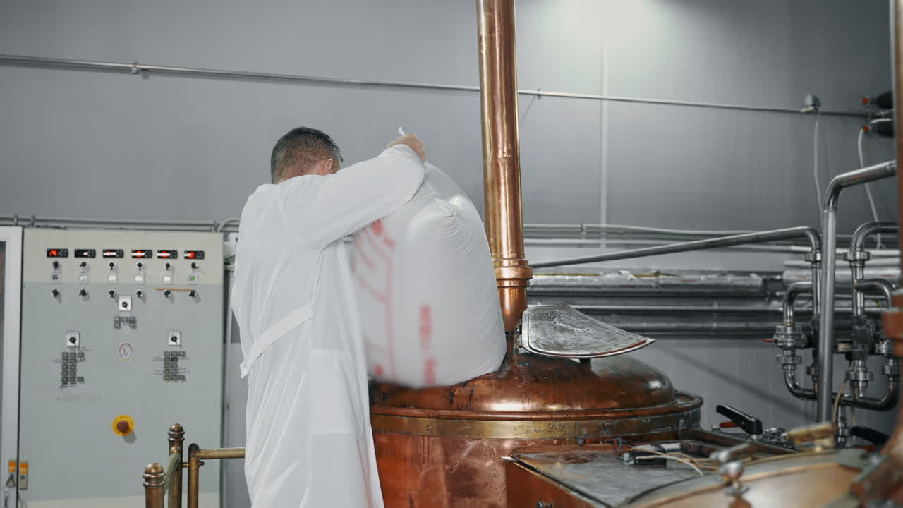 맥주 공장 노동자 가 구리 크 에 재료 를 채우고 있다