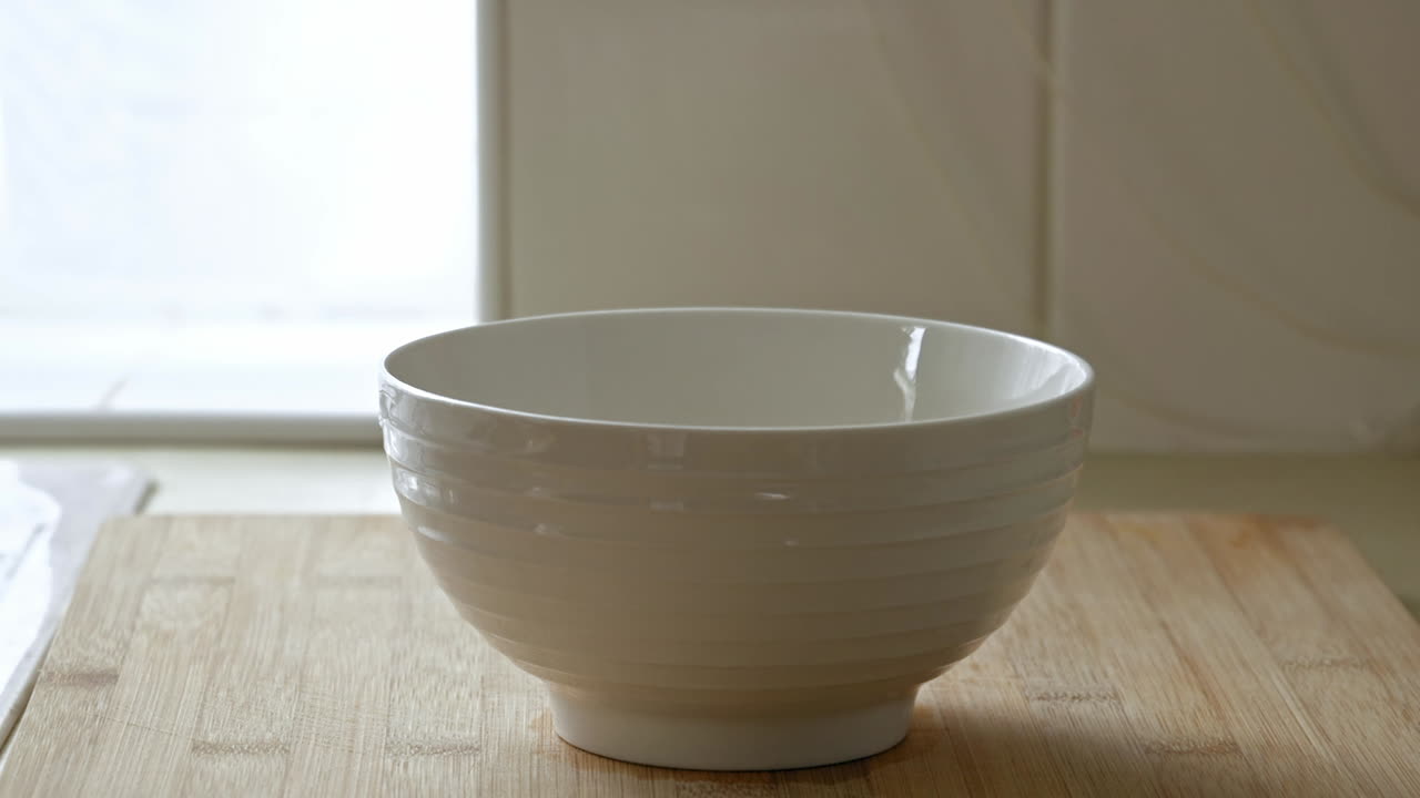 крупный план разбивания яйца в чашку