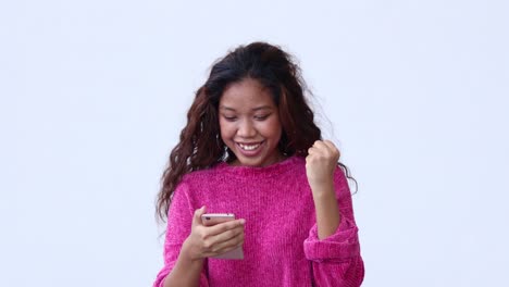 happy young woman uses smartphone online content standing on white background. happy woman enjoying spending time in the social network.