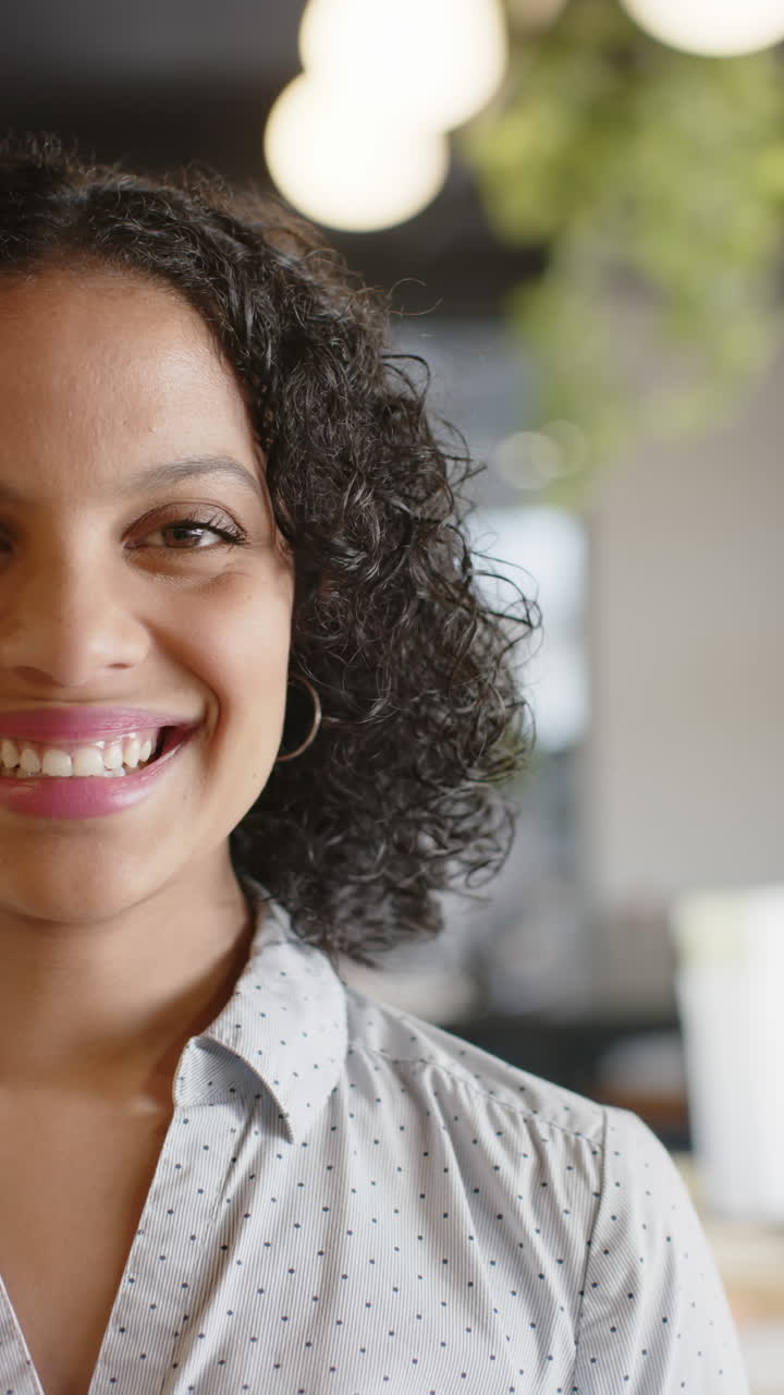 Vertical video of portrait of happy biracial businesswoman in slow motion
