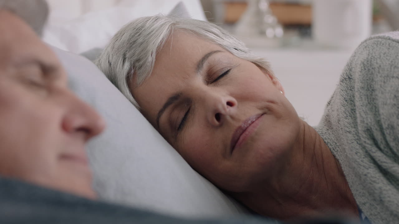 feliz pareja madura acostada en la cama juntos descansando sintiéndose cansada disfrutando relajándose cómodamente en casa en paz jubilación 4k metraje