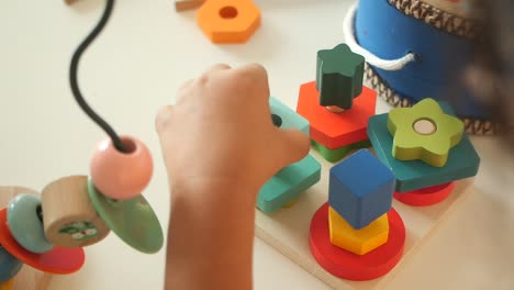 child playing with wooden shape-sorting toys