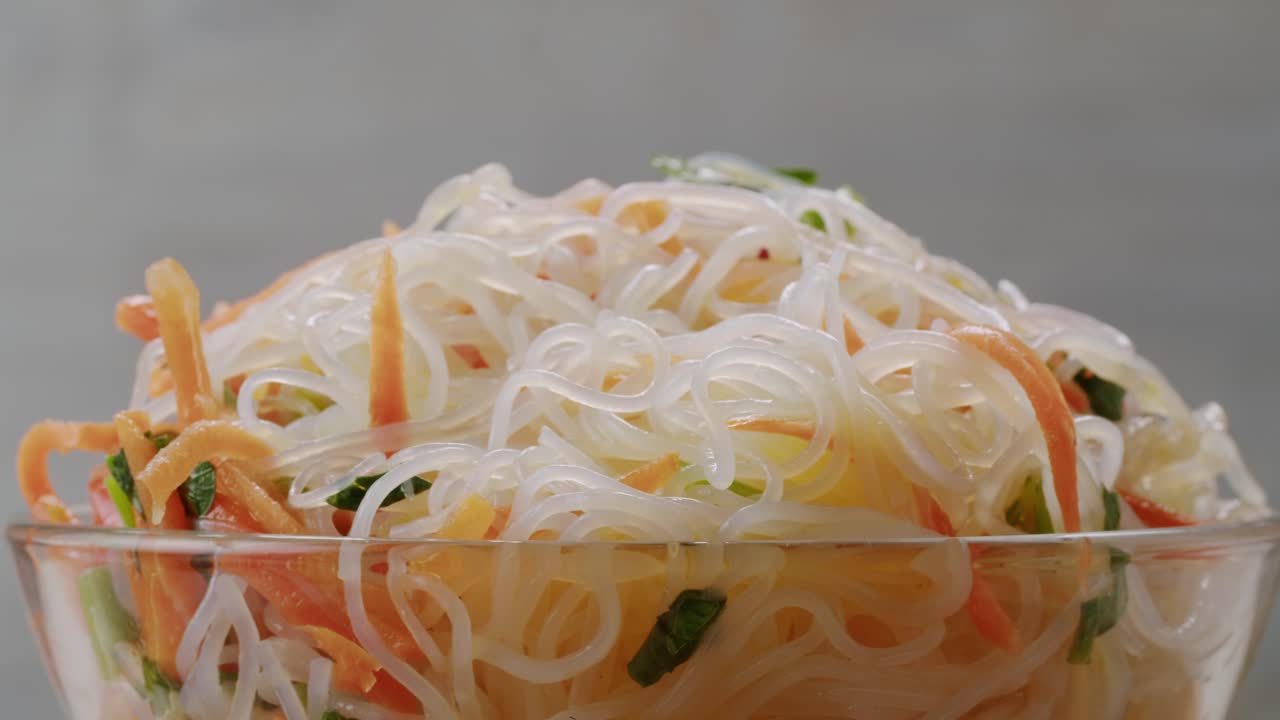 Glass noodles salad with meat and carrots fermented close up asian chinese traditional food.