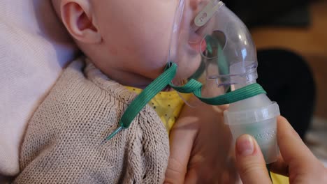 small unrecognizable baby getting steam inhalation, close up view