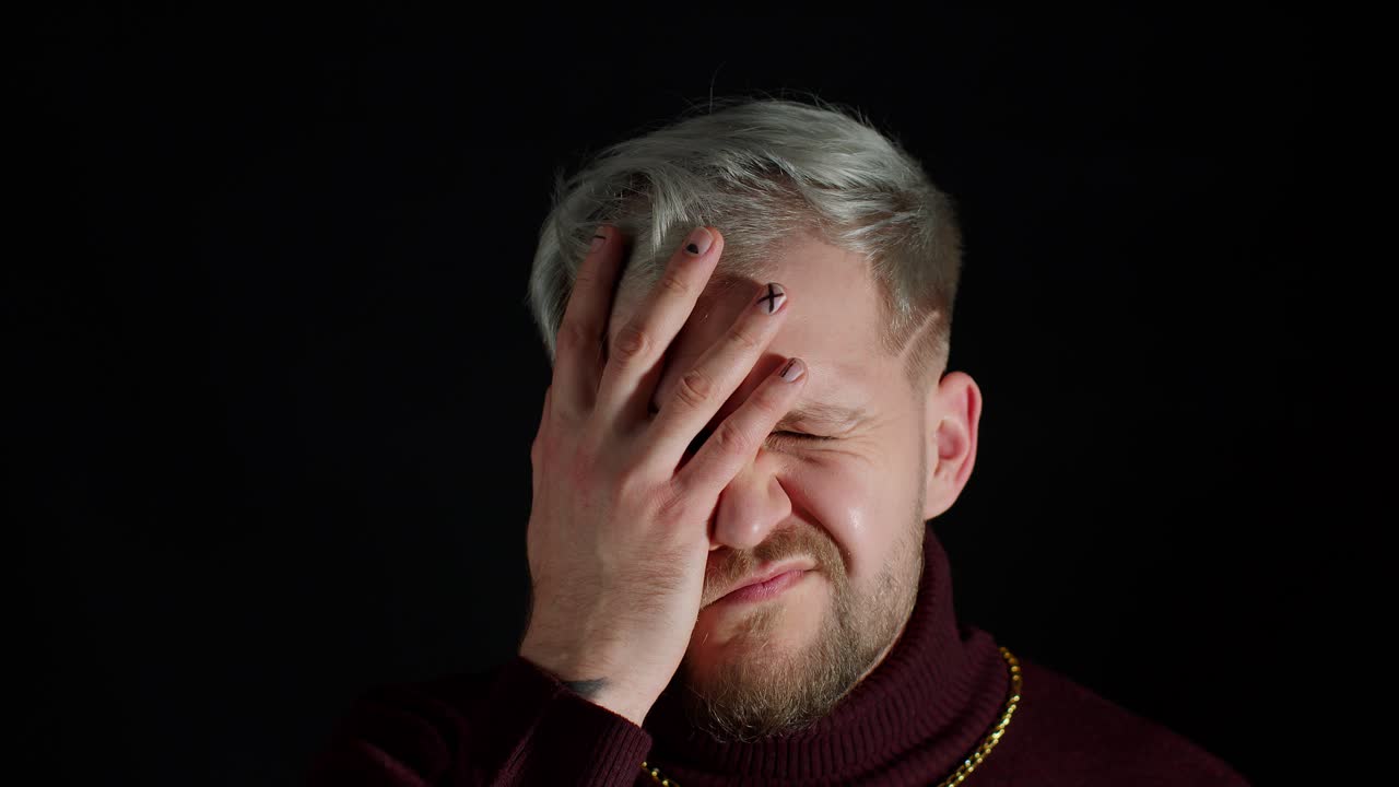 un hombre de cabello blanco y barba con una camisa roja y una cadena de oro.