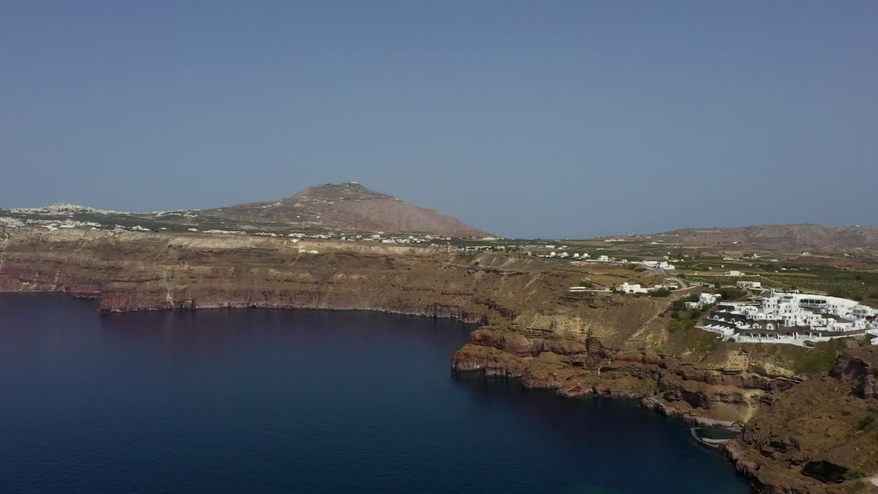 Aerial flying forward across Mediterranean Sea, cliffs and Greek Islands in Santorini, Greece.