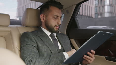 businessman going through documents in car