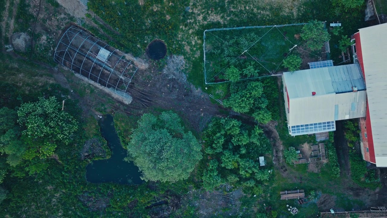 Topdown View Of Farmland With Dirt Path,Greenhouse Frame And Farmhouse. - aerial ascend shot