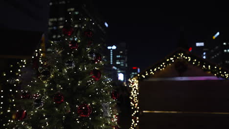 christmas tree with decorative balls and glowing festive lights at night at the gwanghwamun square christmas market in seoul, south korea