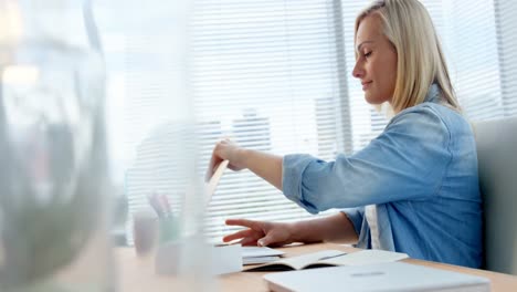 businesswoman opening laptop at her desk