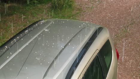 la tormenta de granizo daña el techo del coche con piedras de granizo del tamaño de mármol blanco, cámara lenta 4k