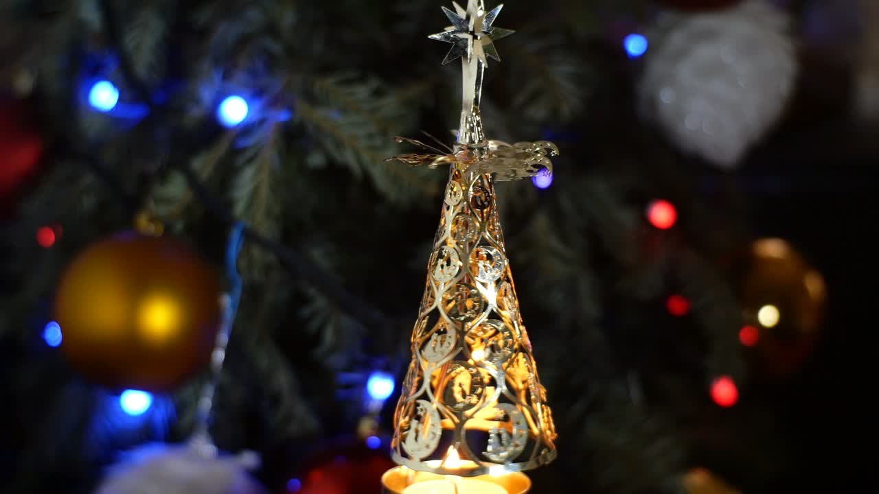 Decorative toy in shape of Christmas tree rotates in circle from energy of candle burning under it.