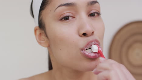 portrait of biracial woman brushing teeth in bathroom